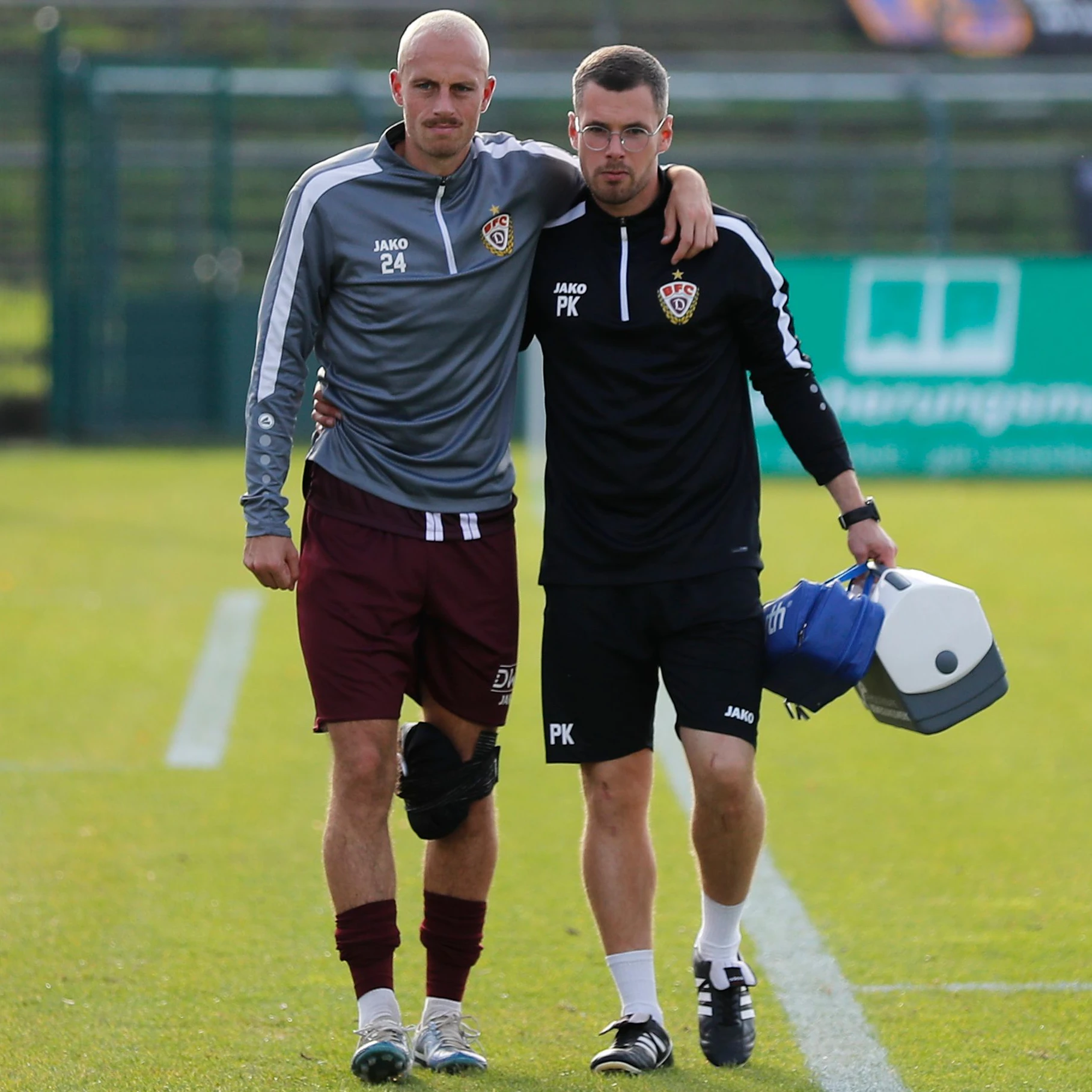 Dicke Eispackung am linken Knie, Steffen Eder (l.) braucht beim Gang in die Kabine die Hilfe von BFC-Physio Pascal Kämper.