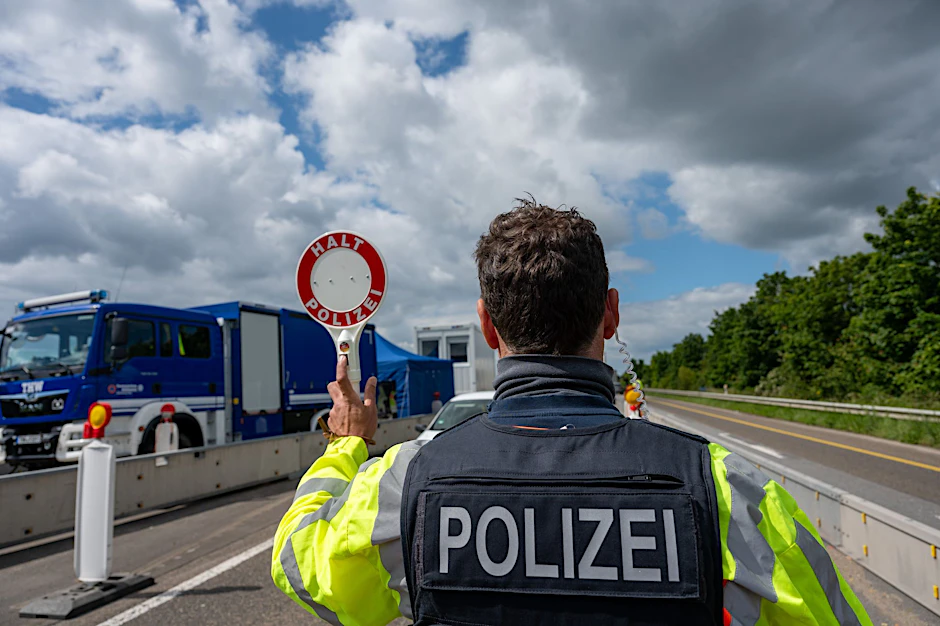 Grenzkontrollen gegen irreguläre Migration: Ein Bundespolizist hält auf der Autobahn mit einer Kelle ein Fahrzeug an.