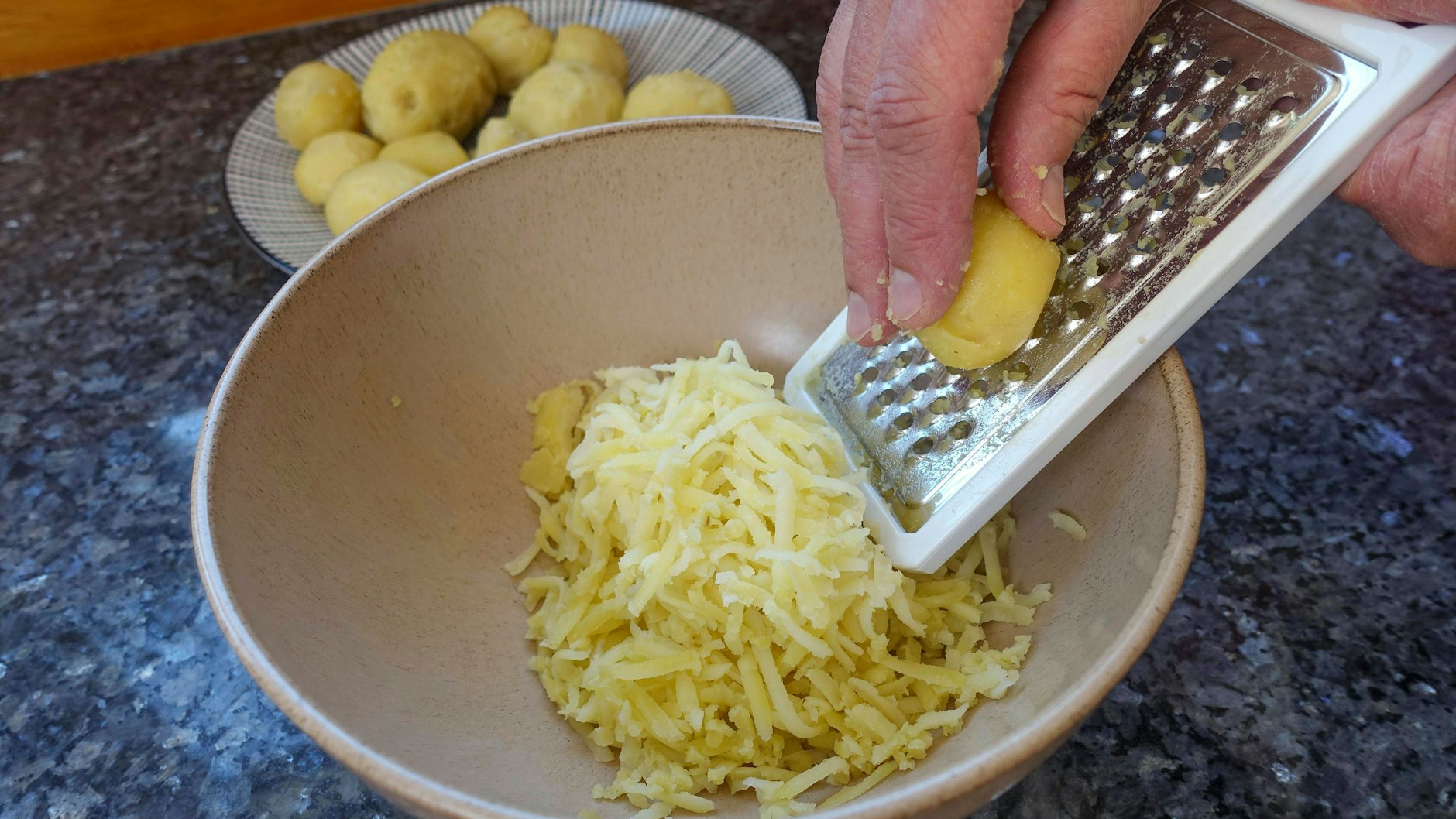 Bei der Zottelsuppe kommen die Kartoffeln gerieben ins kochende Wasser oder die Brühe.