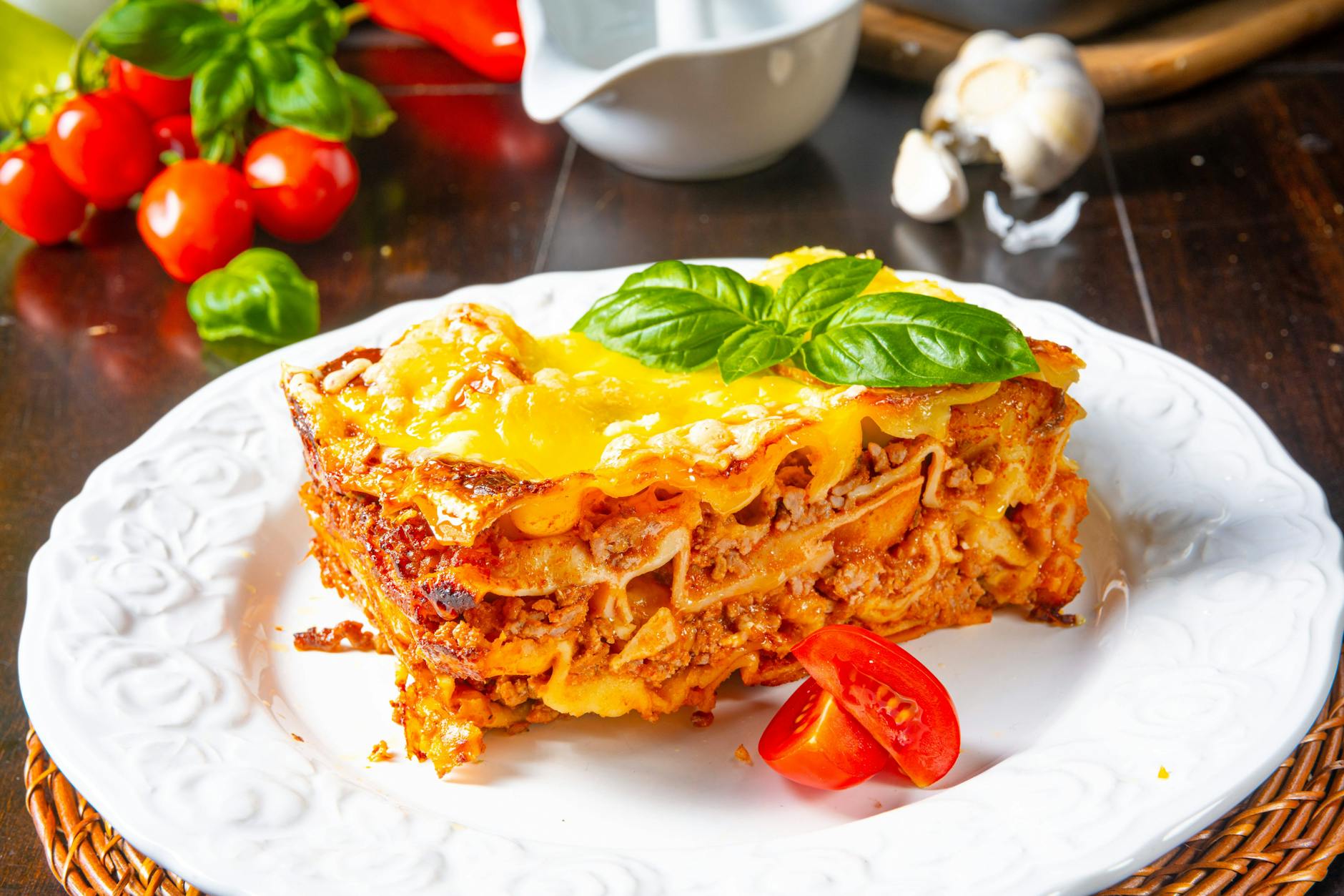 Authentische italienische Lasagne, frisch aus dem Ofen, goldbraun gebacken und serviert mit einem Basilikumblatt. Mit diesem Rezept bekommen Sie sie perfekt hin.