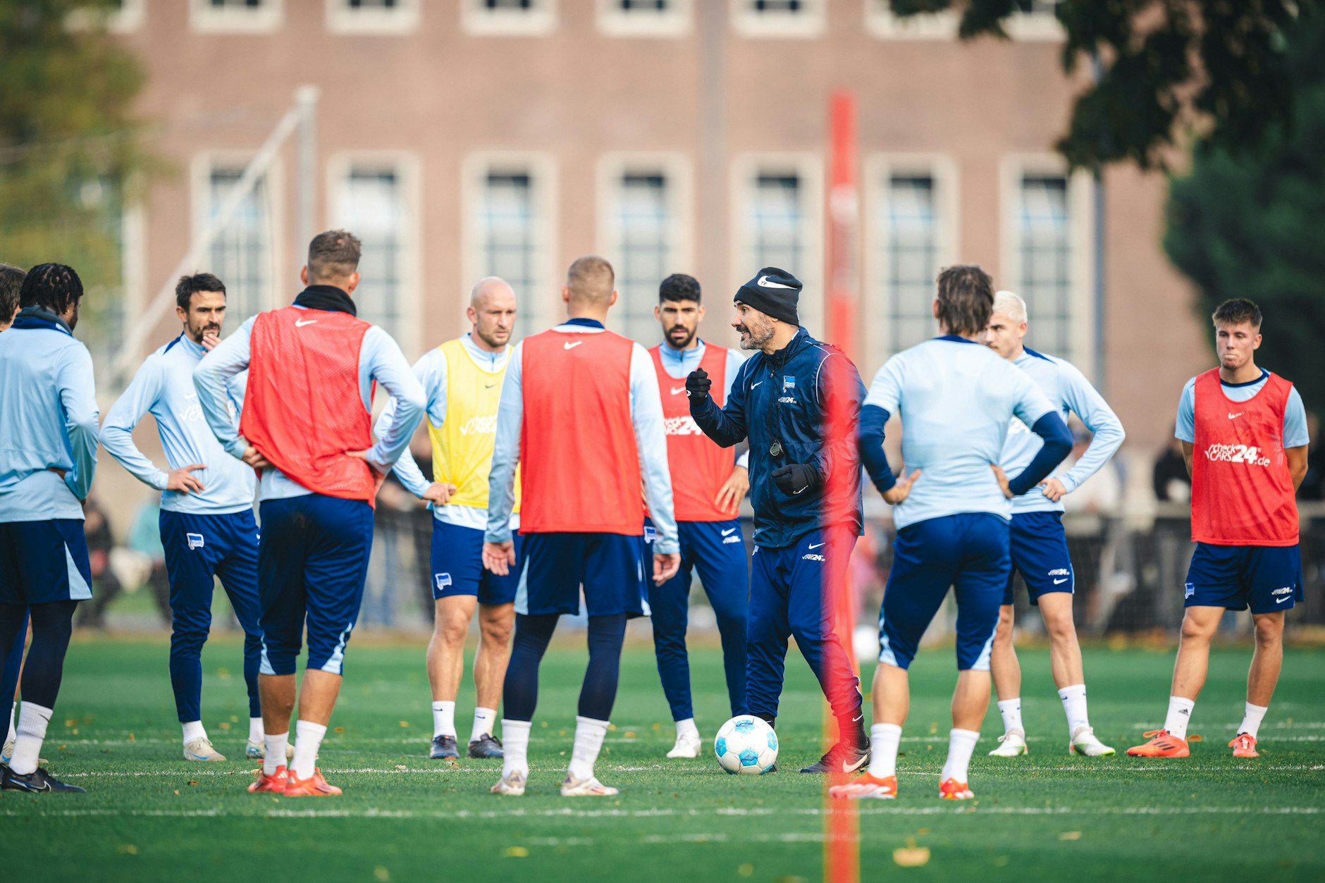 Trainer Cristian Fiel spricht im Training von Hertha BSC die Dinge im Spielerkreis klar an.
