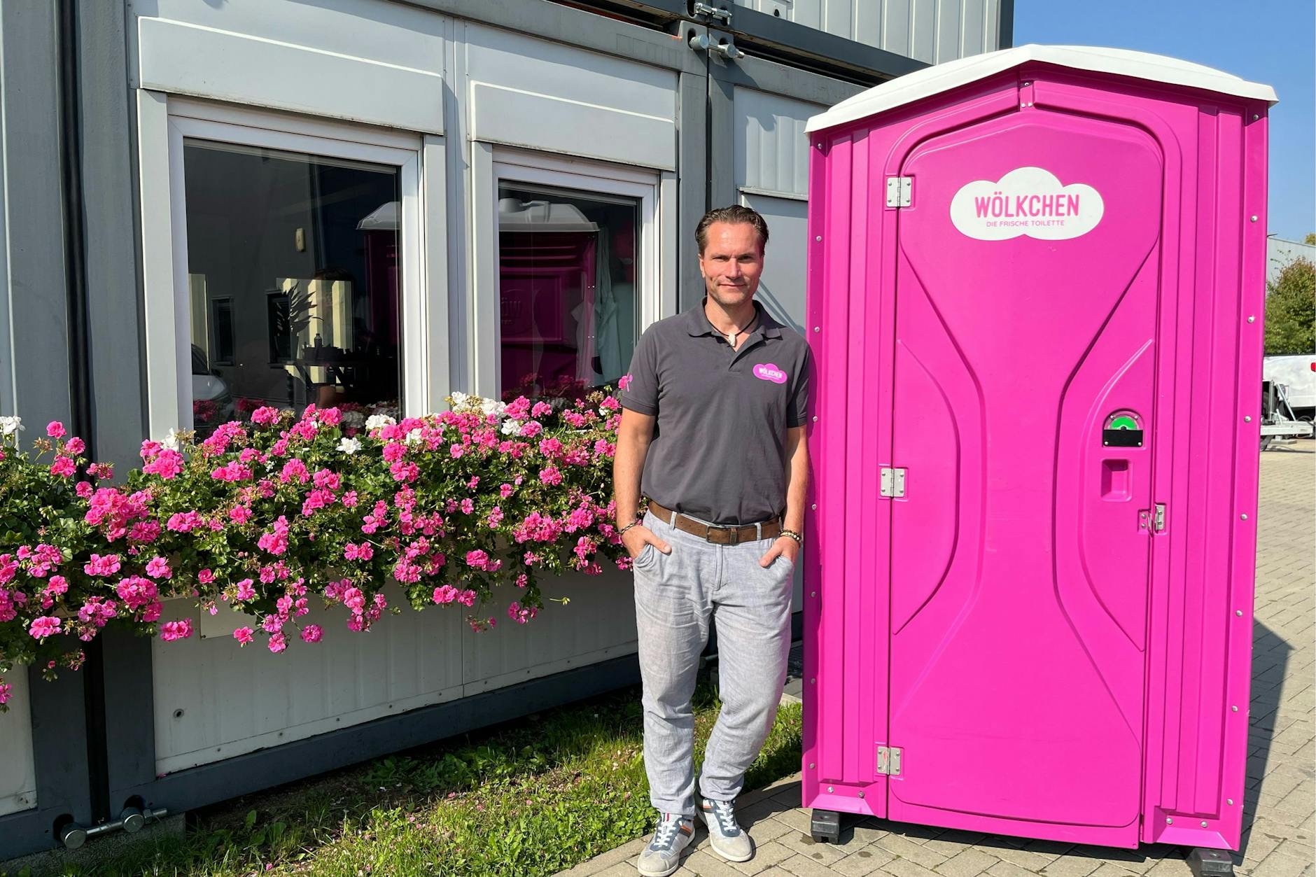 Pink sind die Geranien und pink ist das mobile Häuschen. Vertriebsleiter Heiko Stellmacher lehnt an der 75 Kilo schweren, frisch geputzten Toilette.