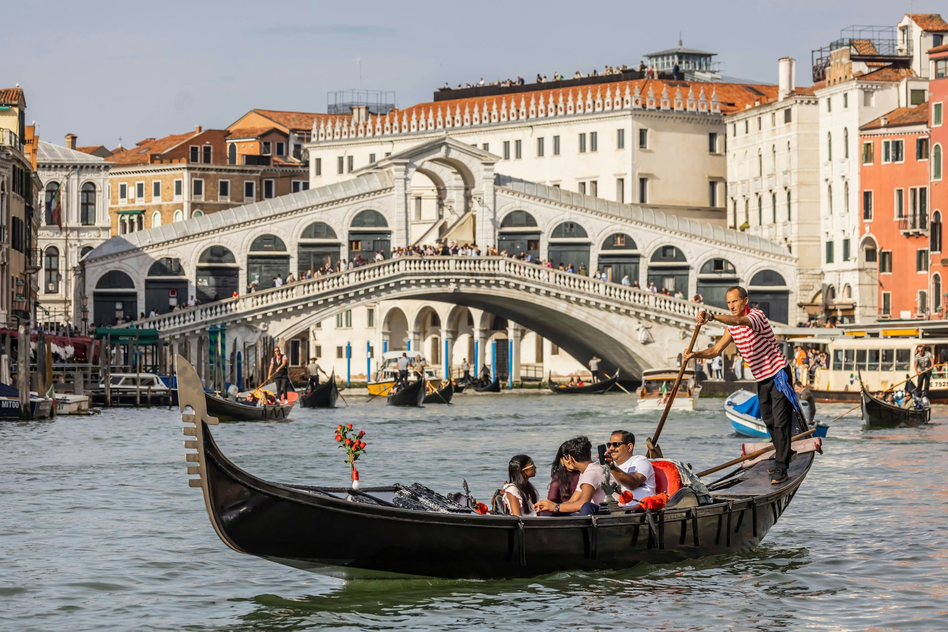 Venezianische Gondel unterwegs auf den Kanälen von Venedig. Kanal Grande mit Rialtobrücke. 