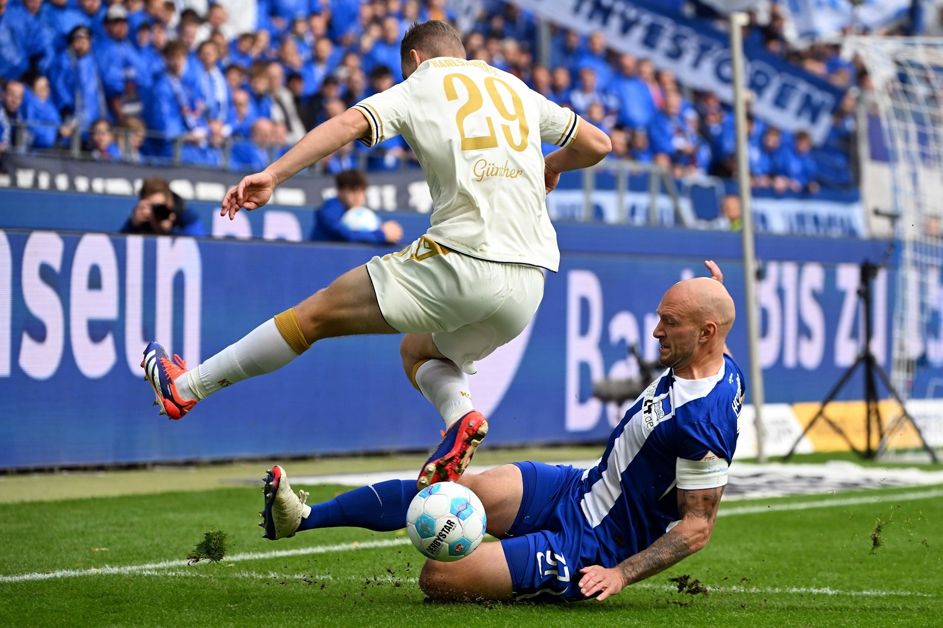Hertha-Kapitän Toni Leistner setzt zur Grätsche gegen Karlsruhes Lasse Günther an.