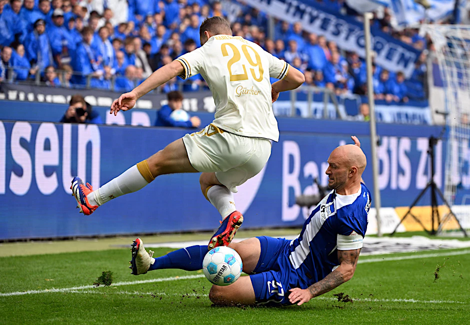 Hertha-Kapitän Toni Leistner setzt zur Grätsche gegen Karlsruhes Lasse Günther an.