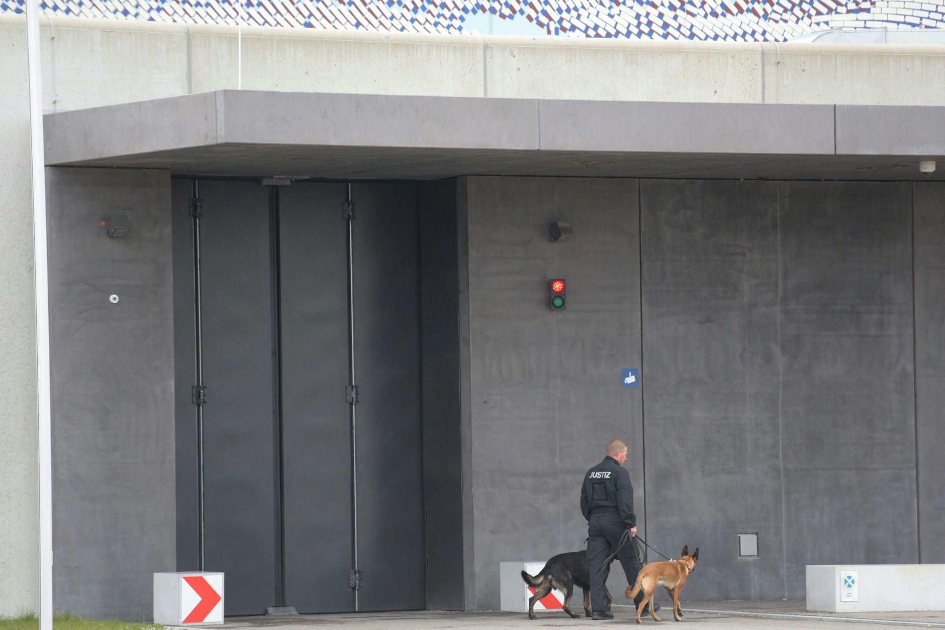 Ein Justizangehöriger mit zwei Hunden vor der Justizvollzugsanstalt Augsburg-Gablingen. Hier sollen Häftlinge misshandelt worden sein.