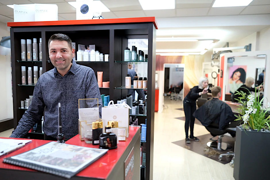 „Wat soll denn Schönet jemacht werden?“ Daniel&nbsp;Reimann am Tresen seines Friseurladens in Hellersdorf.
