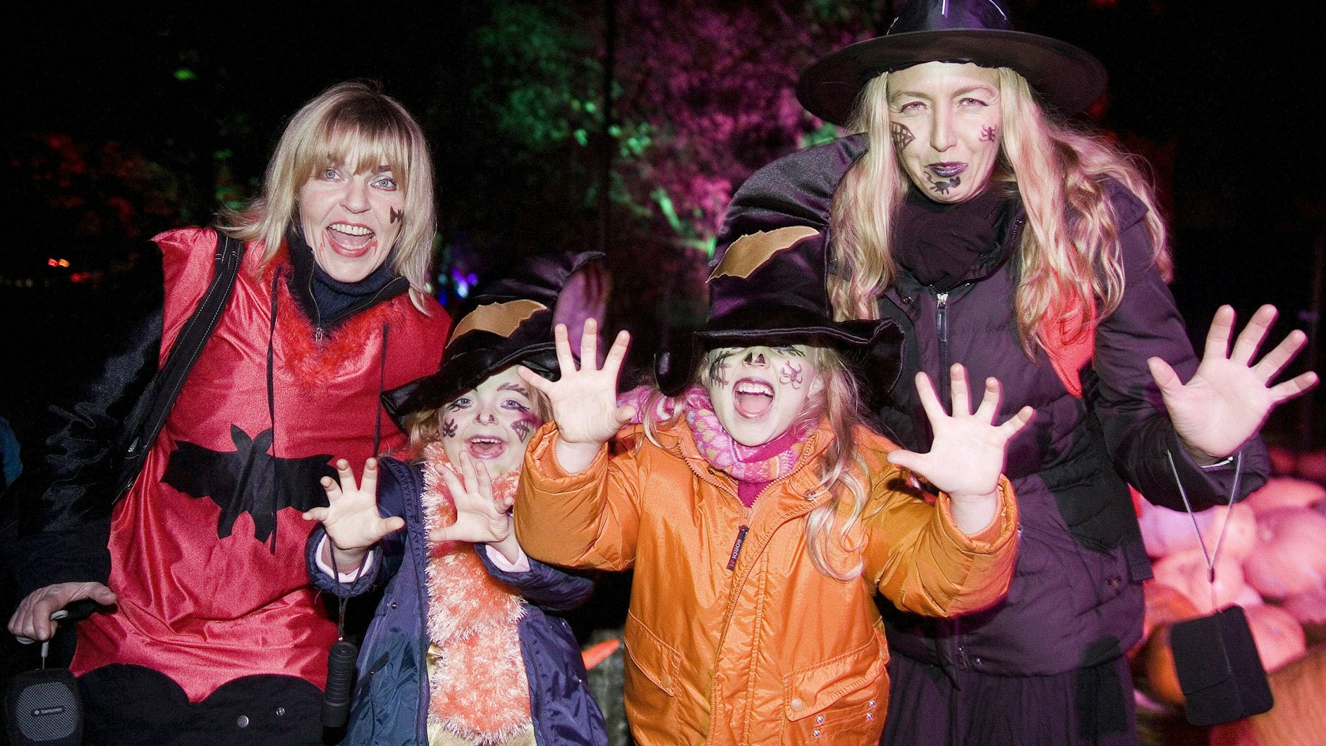 Kinder feiern mit ihren Müttern Halloween.