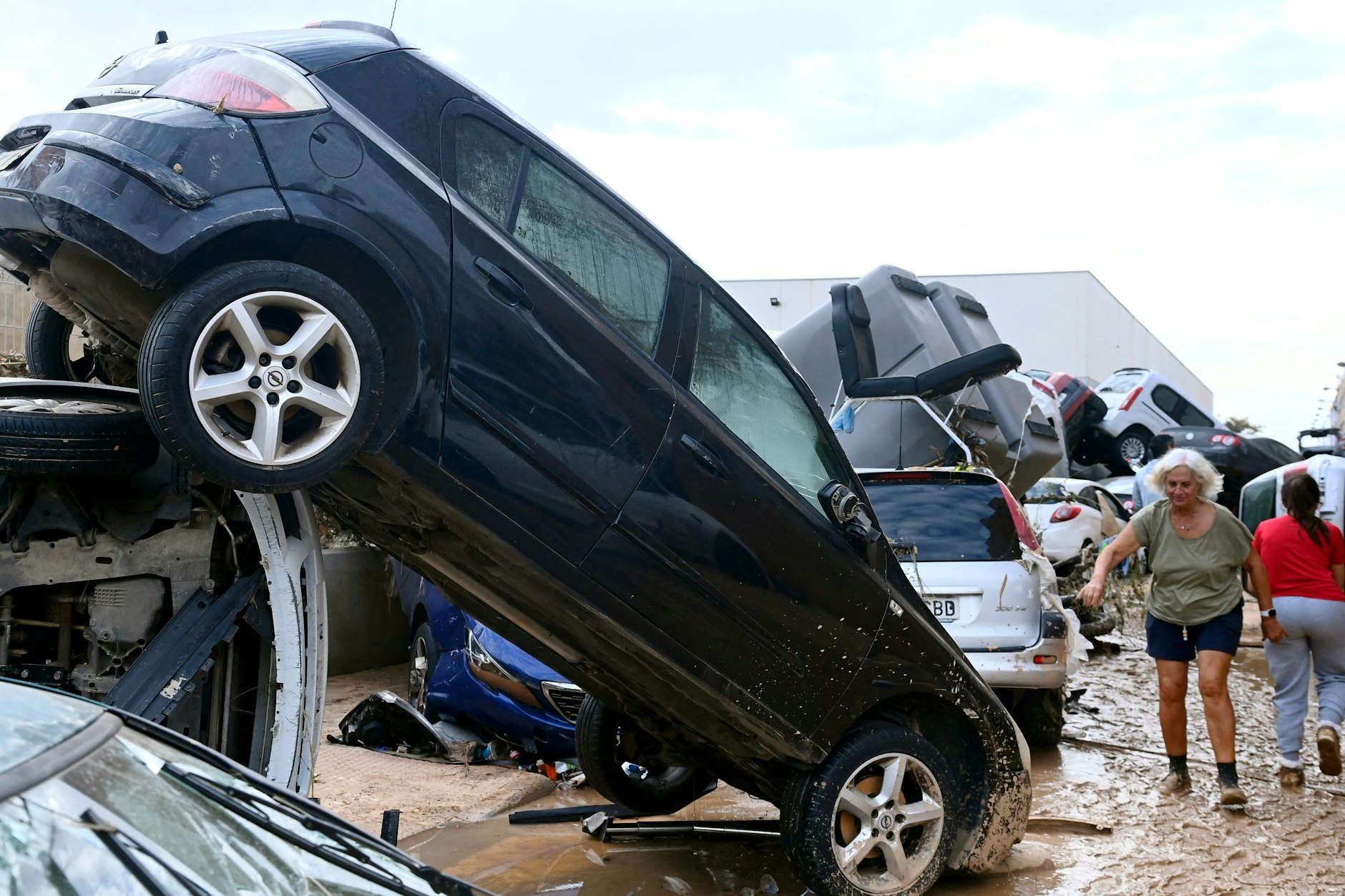 Autowracks und Trümmer stapeln sich am 31. Oktober 2024 in den Straßen von Paiporta, die von Schlamm bedeckt sind, nachdem Sturzfluten dieses Gebiet in der Region Valencia im Osten Spaniens verwüstet haben. 