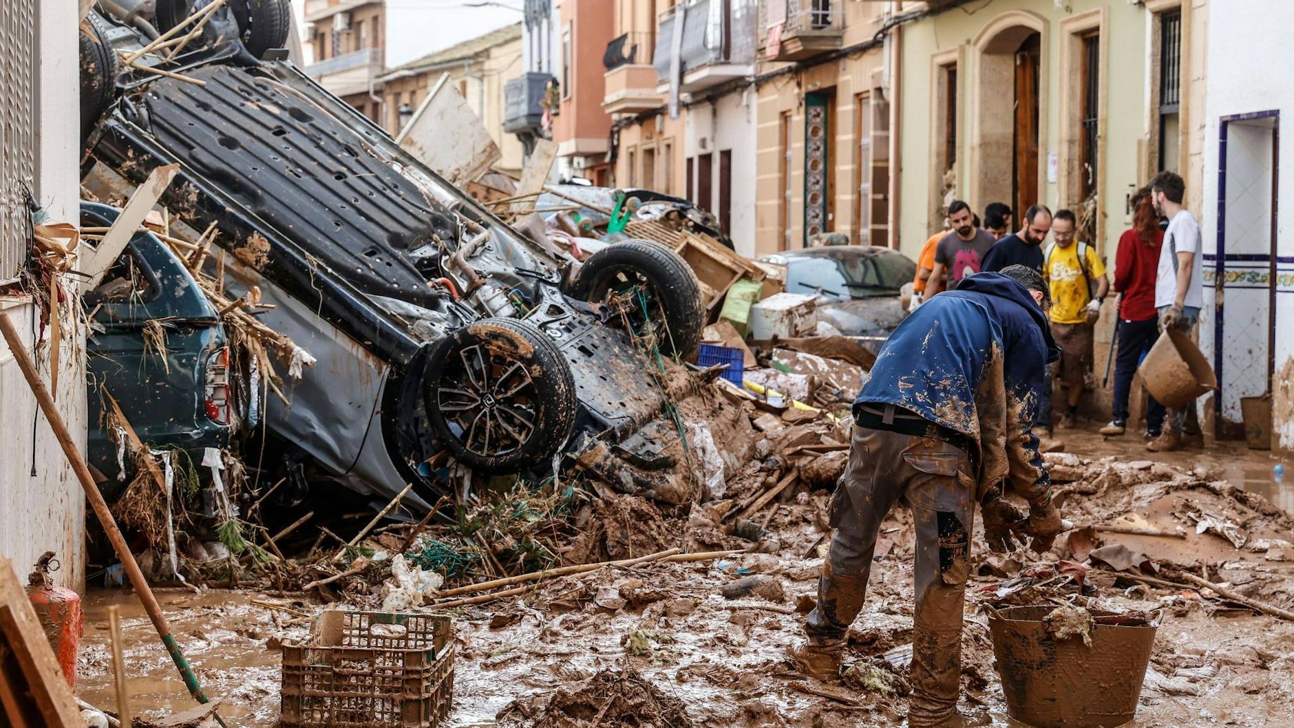 Noch immer stapeln sich vielerorts ineinandergeschobene Autos, ganze Orte sind mit Schlamm überzogen und von der Außenwelt abgeschnitten – die Aufräumarbeiten in Spanien werden wohl lange Zeit in Anspruch nehmen.