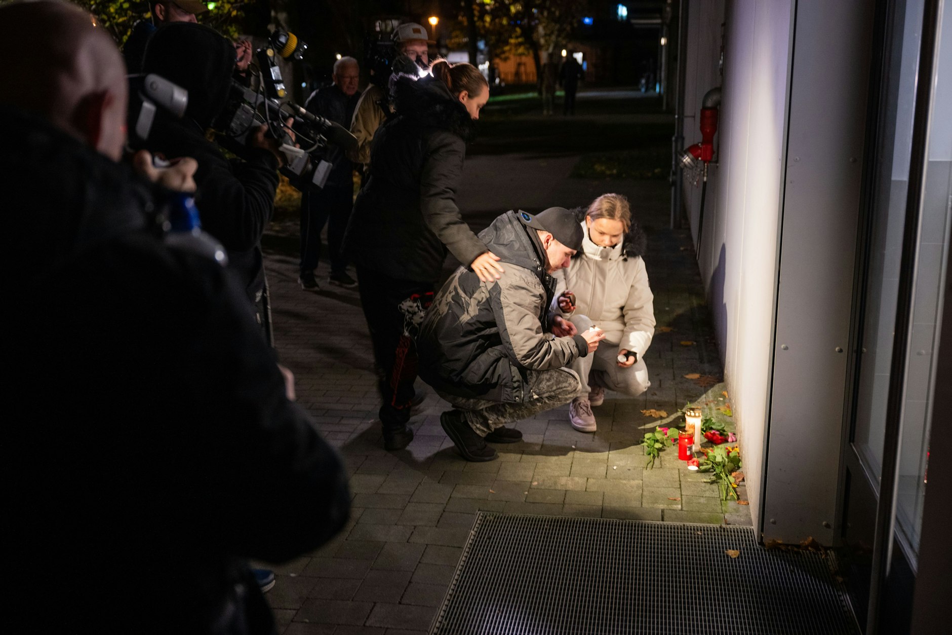Menschen legten vor dem Mehrfamilienhaus am Abend bereits Blumen und Kerzen nieder.