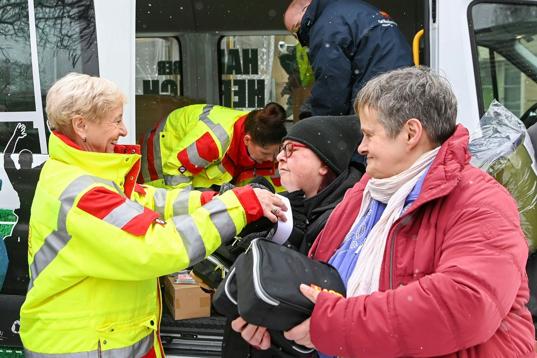 Die ASB-Mitarbeiterin Sonja Diehl (l-r) verteilt an Betty und Conny bei einer Kältehilfe-Aktion Schlafsäcke und Pflege-Sets für Obdachlose und wohnungslose Menschen vor der Suppenküche der Volkssolidarität Potsdam. (Archiv)