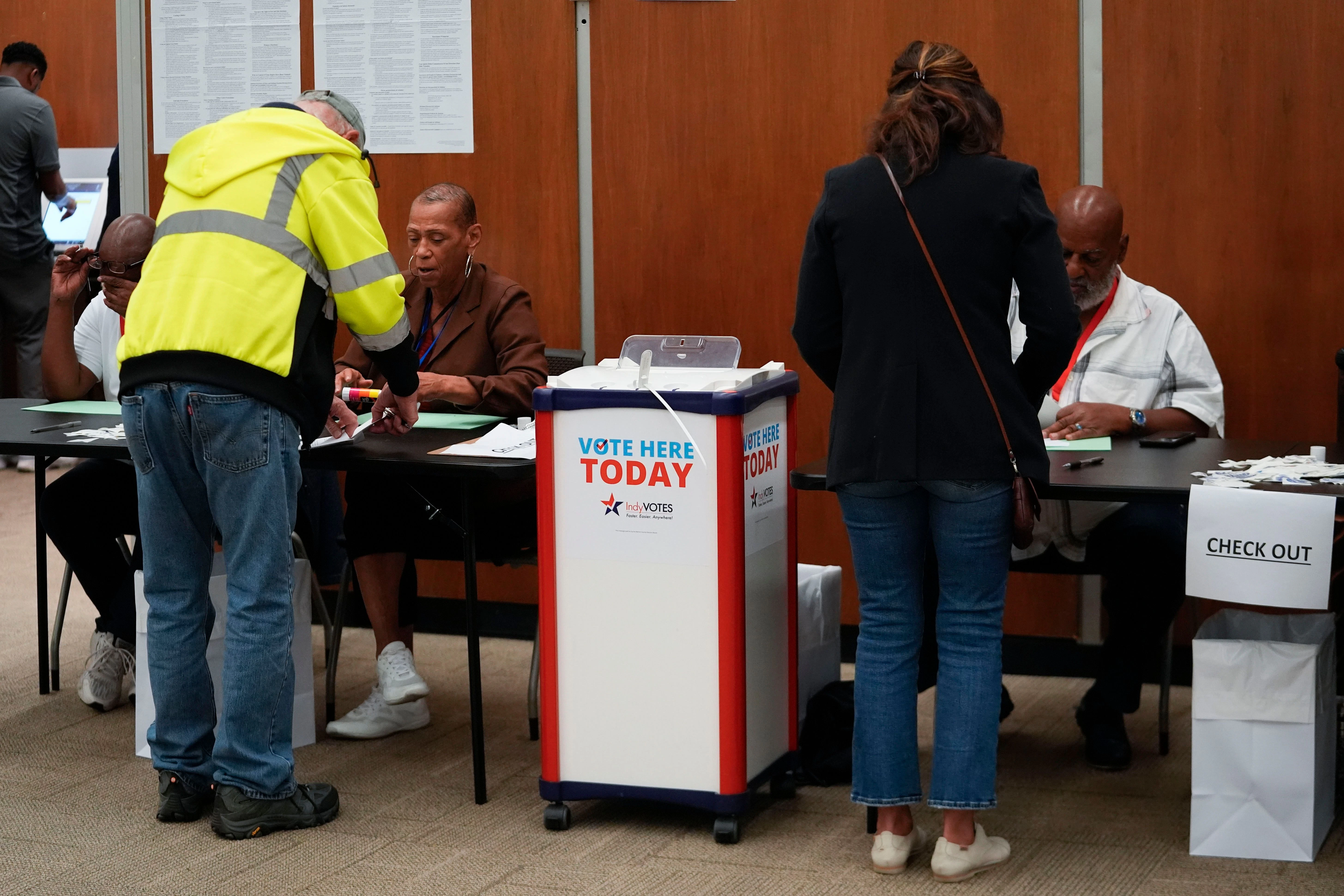 08.10.2024, USA, Indianapolis: Wähler lassen sich ihre Stimmzettel bei der persönlichen Briefwahl im City-County Building bestätigen. 