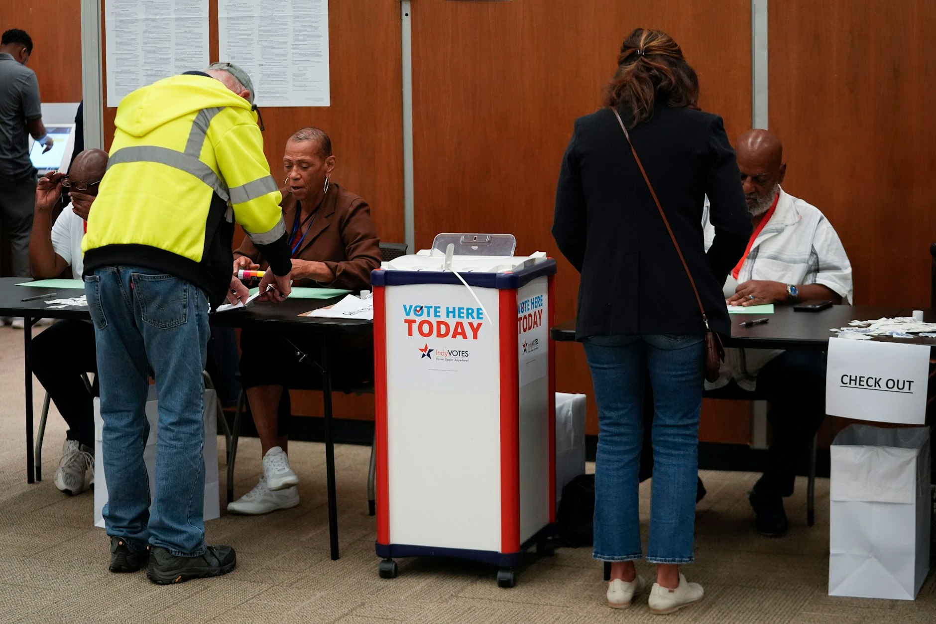 08.10.2024, USA, Indianapolis: Wähler lassen sich ihre Stimmzettel bei der persönlichen Briefwahl im City-County Building bestätigen. 