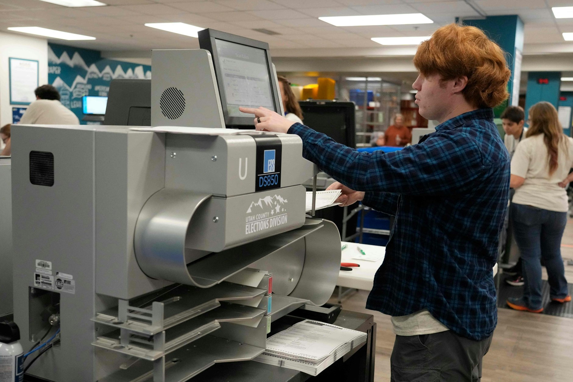 Ein Wahlhelfer legt die Stimmzettel in einen automatischen Auszähler in Provo, Utah.