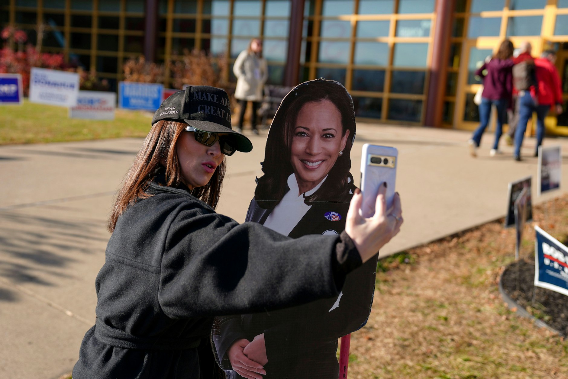 Eine Frau macht ein Selfie mit einer Figur der demokratischen Präsidentschaftskandidatin und Vizepräsidentin Kamala Harris.