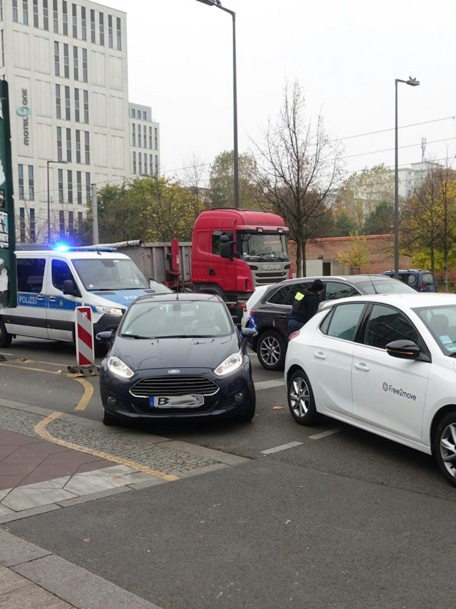 Eine Polizistin läuft von Auto zu Auto und belehrt die Fahrer über das Abbiegeverbot.