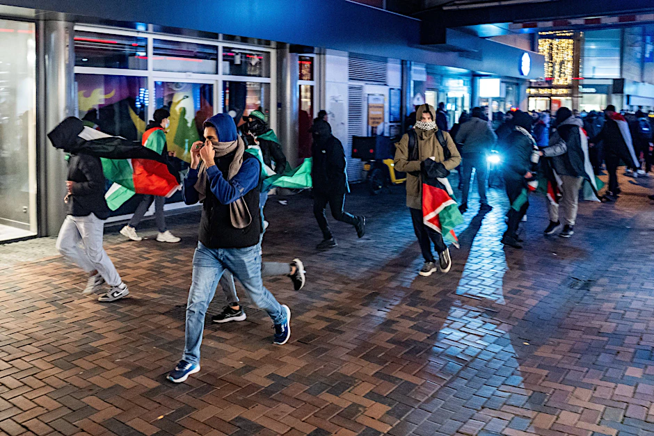 Propalästinensische Demonstranten laufen zum Teil vermummt durch Amsterdam.