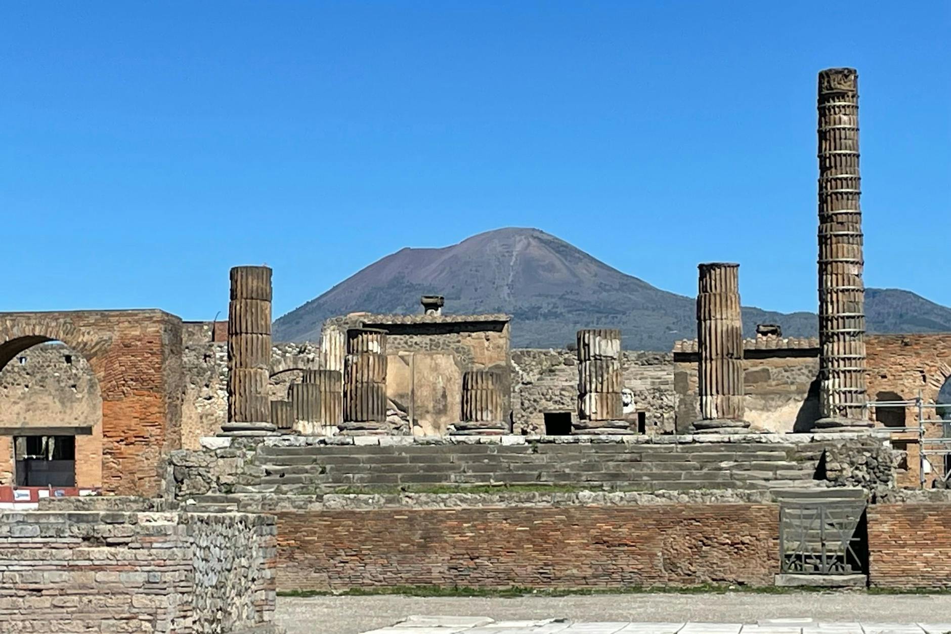Antike Gebäude in Pompeji mit dem Vesuv im Hintergrund.