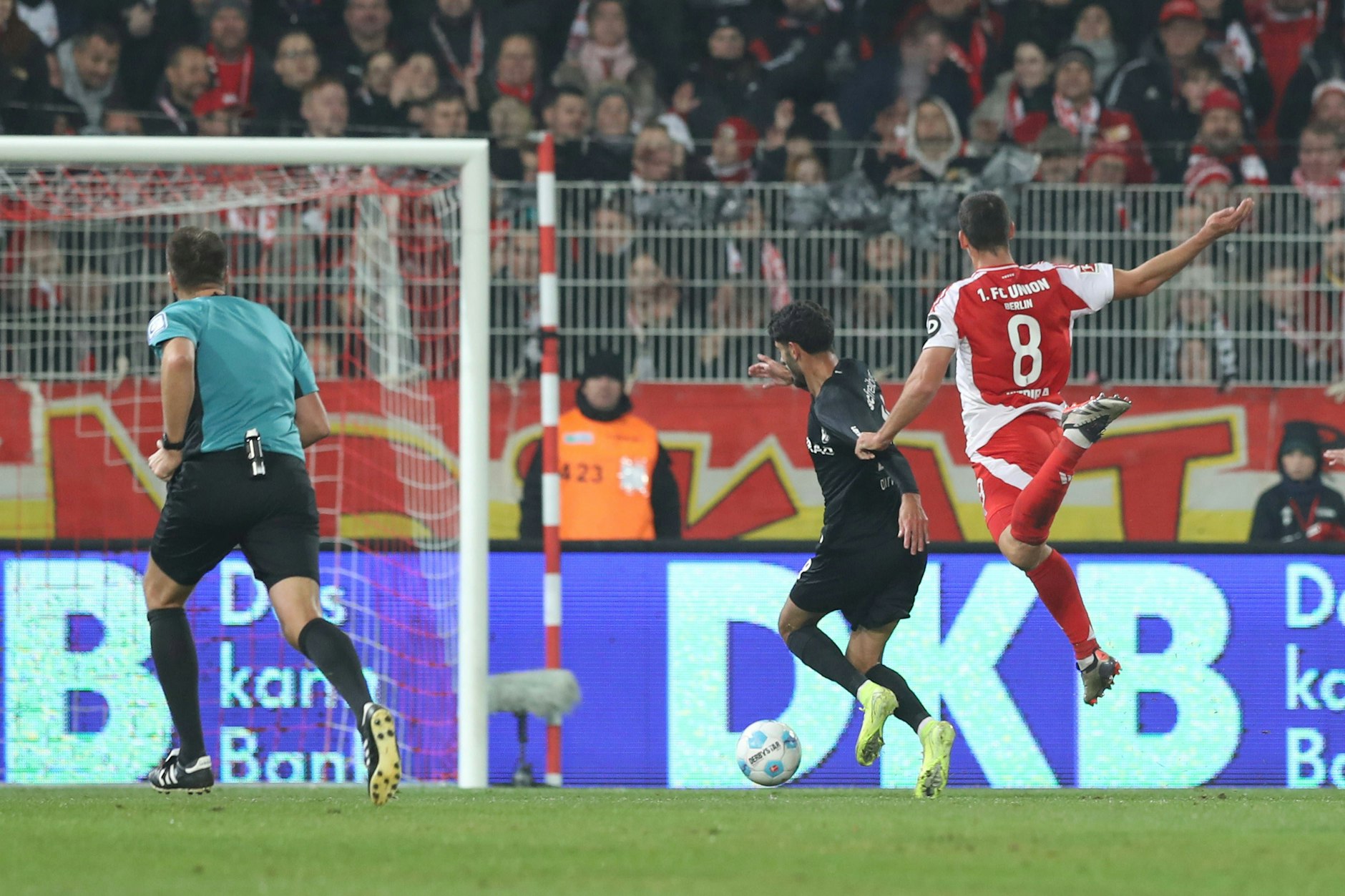 Rani Khedira (30), Mittelfeldchef des 1. FC Union, hält Freiburgs Erin Dinkci (22) und bringt den Stürmer letztlich im Strafraum zu Fall.