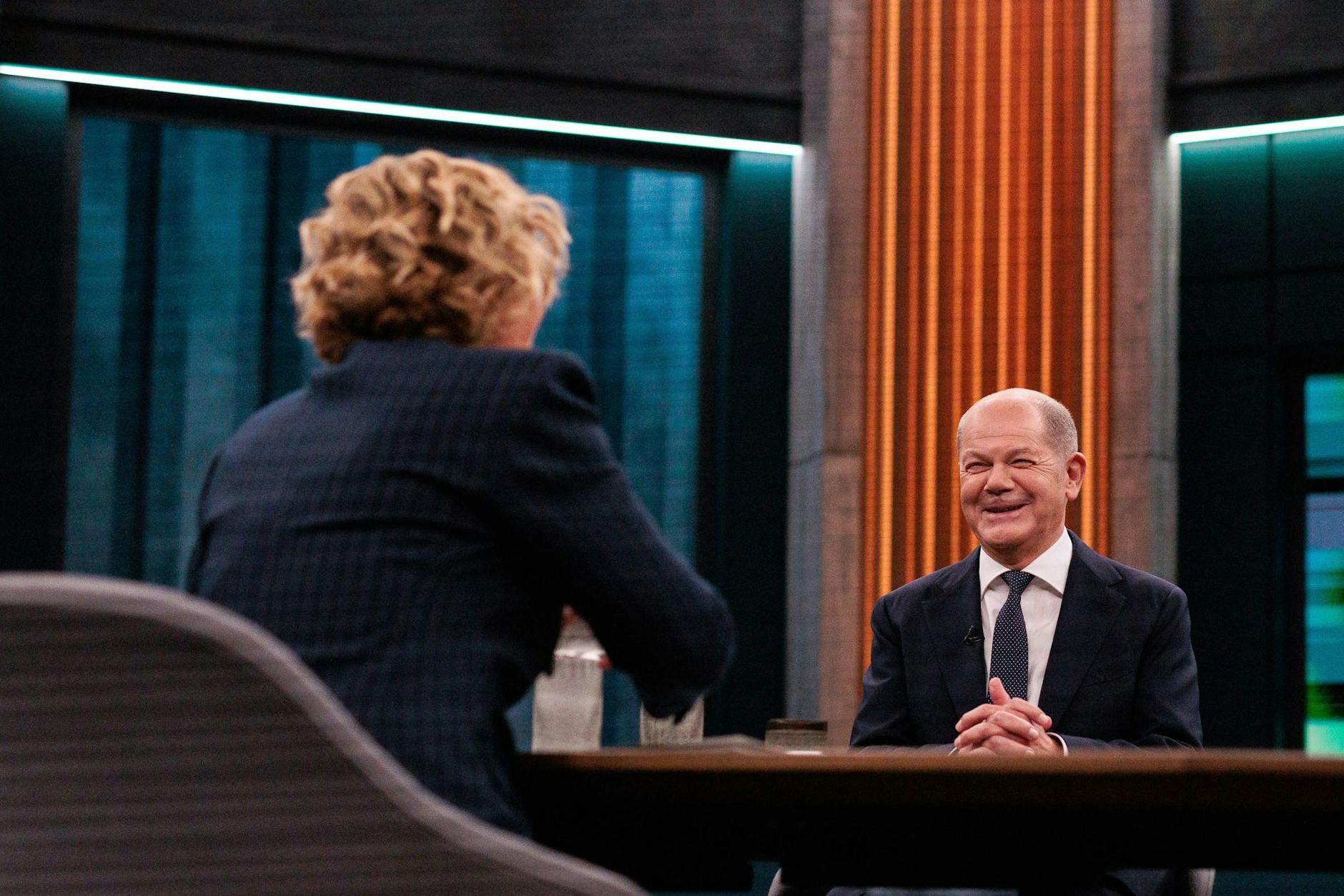 Bundeskanzler Olaf Scholz (SPD) sitzt neben Caren Miosga (l) im Fernsehstudio vor dem Liveinterview der ARD-Sendung „Caren Miosga“.
