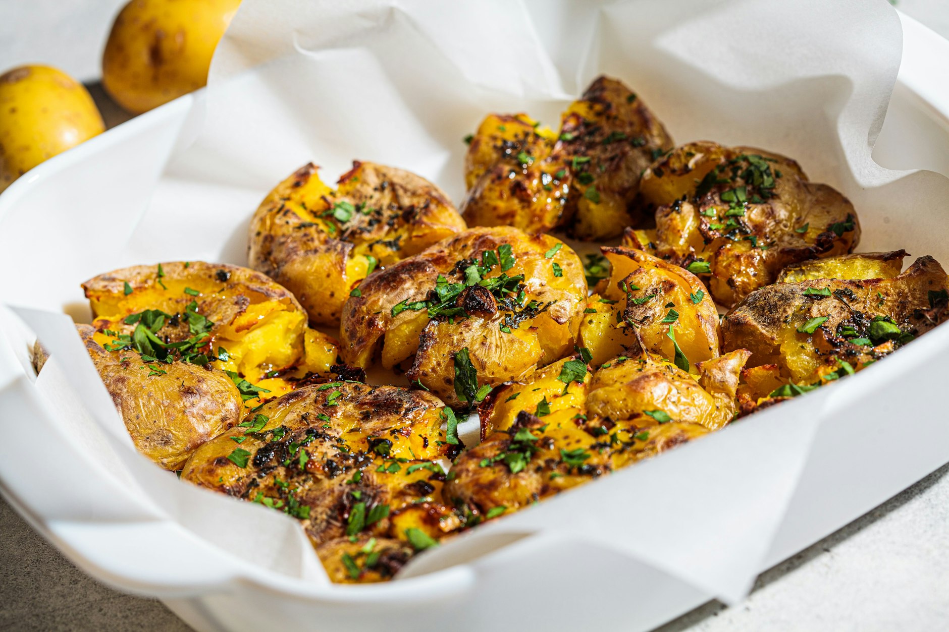 Diese leckeren Smashed Potatoes aus dem Backofen sind knusprig und weich zugleich. Parmesan und Knoblauch geben ihnen ein unglaubliches Aroma.