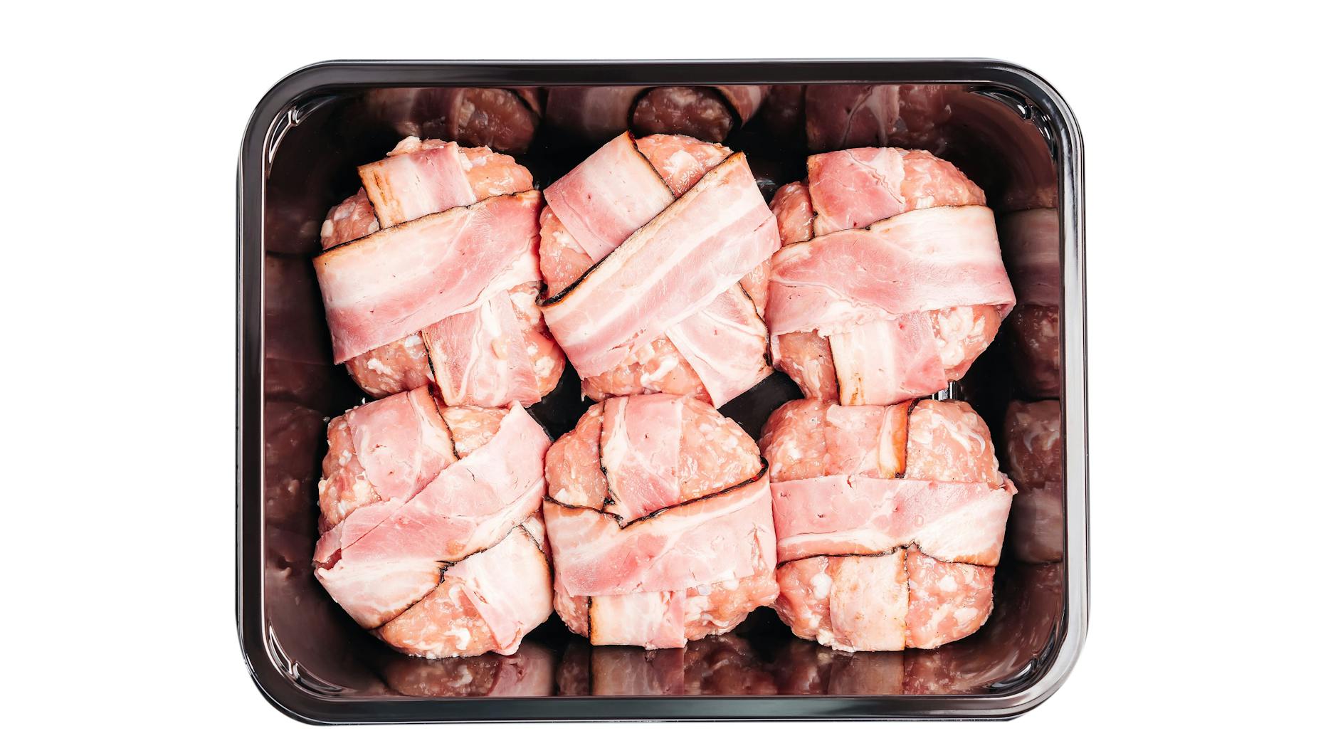 Die Hackfleisch-Kugeln werden mit den Speck-Streifen umwickelt, bevor sie in die Pfanne gebraten werden.
