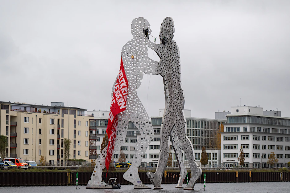 Polizisten entfernen ein Banner, das Aktivisten auf der Skulptur „Molecule Man“ in der Spree angebracht hatten.