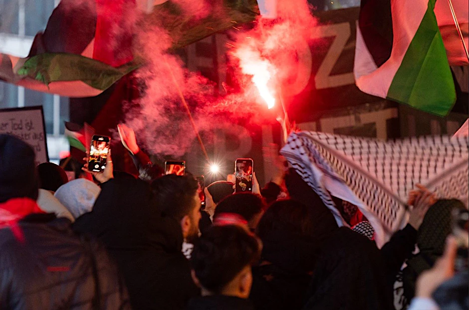 Berlin: Ein Teilnehmer der propalästinensischen Demonstration zündet eine Bengalische Fackel.