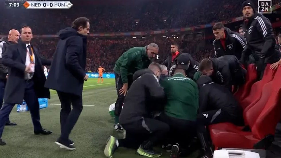 Spieler und Betreuer kümmern sich um den kollabierten Adam Szalai .