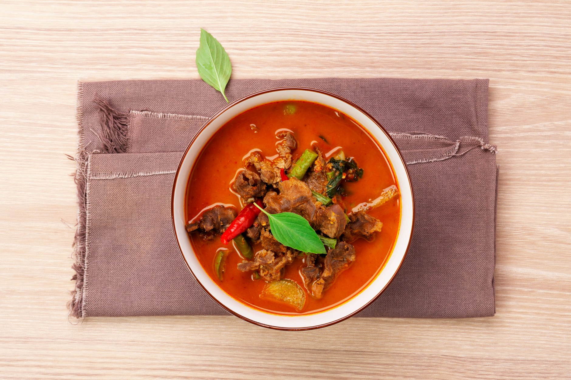 Im Restaurant steht das rote Thai-Curry als „Kaeng Phet“ auf der Karte, was übersetzt „Scharfe Suppe“ bedeutet.