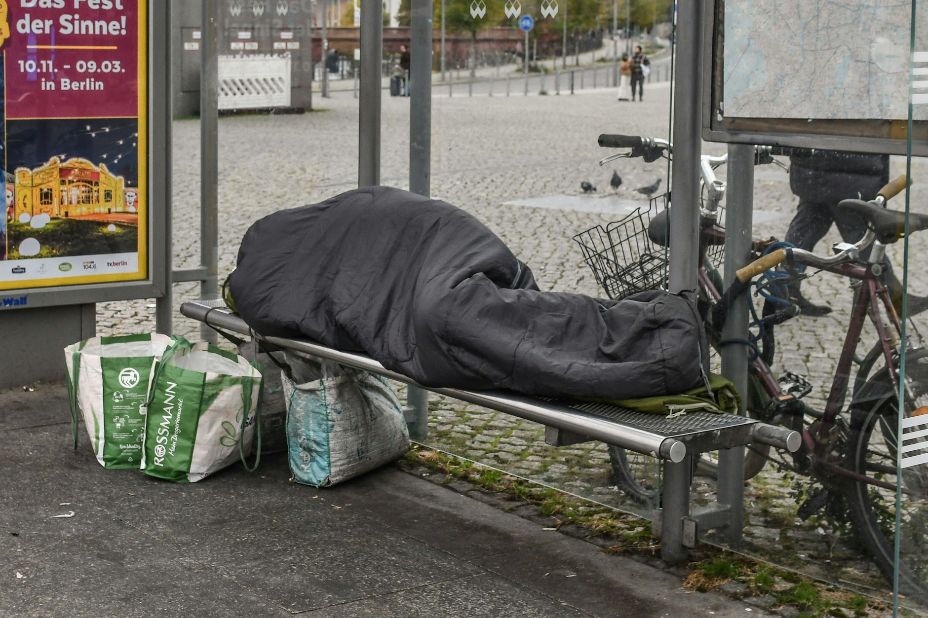 Notdürftig mit einem Schlafsack vor der Kälte geschützt: Ein Obdachloser schläft in einem Wartehäuschen am Berliner Hauptbahnhof.