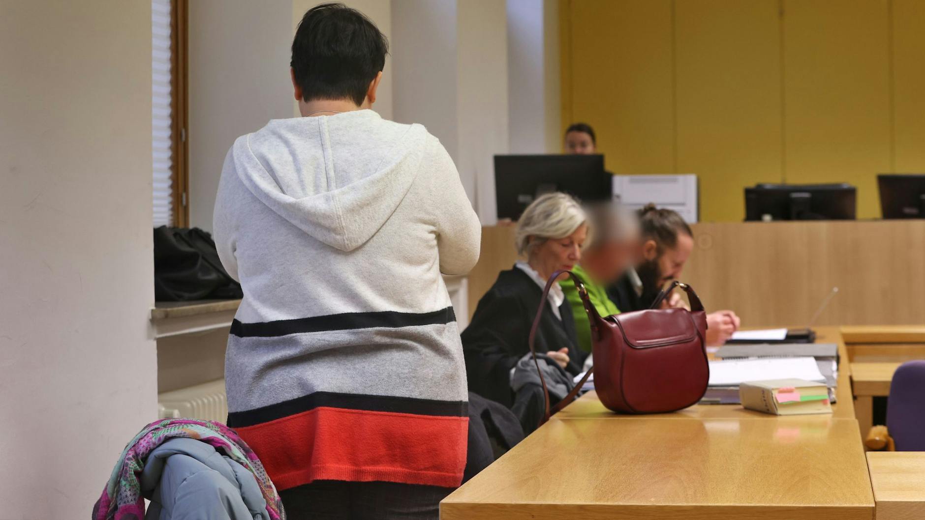 Im Vordergrund die angeklagte Mutter (stehend), im Hintergrund im grünen Pullover der ebenfalls angeklagte Vater der verstorbenen Jugendlichen. Sie haben die Verantwortung für das Geschehen übernommen.