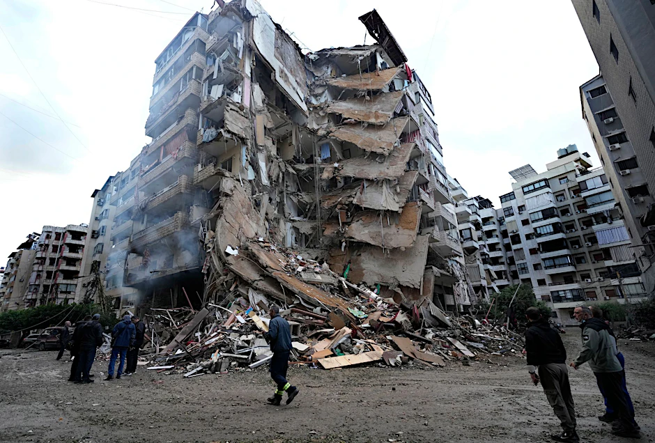 Anwohner versammeln sich vor einem zerstörten Gebäude, das Sonntagnacht bei einem israelischen Luftangriff in Dahieh, Libanon, getroffen wurde.