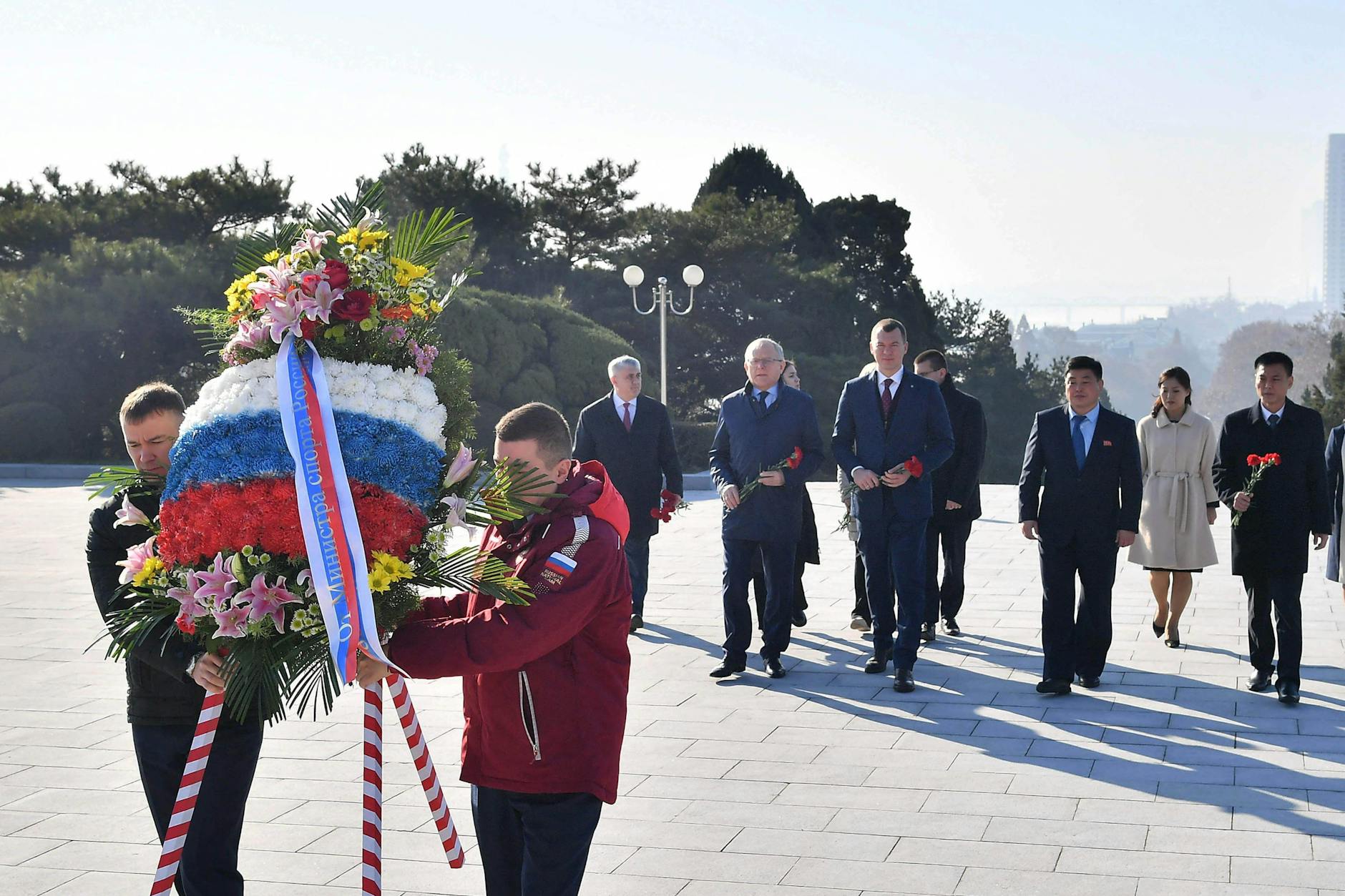 Kooperation in vielen Bereichen: Der russische Sportminister Michail Degtjarew (M.) bei einer Kranzniederlegung vor dem Befreiungsturm in Pjöngjang, Nordkorea