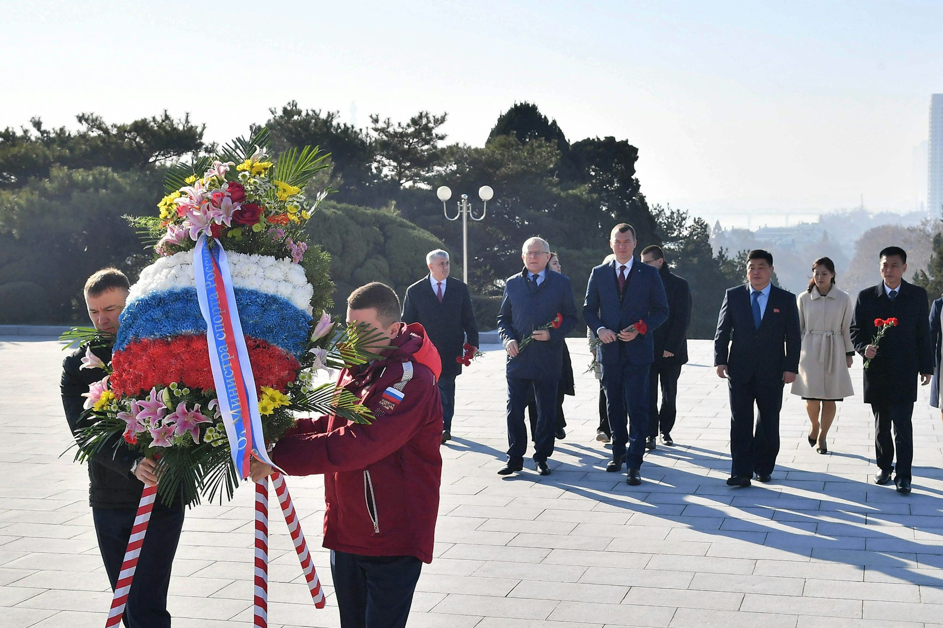Kooperation in vielen Bereichen: Der russische Sportminister Michail Degtjarew (M.) bei einer Kranzniederlegung vor dem Befreiungsturm in Pjöngjang, Nordkorea