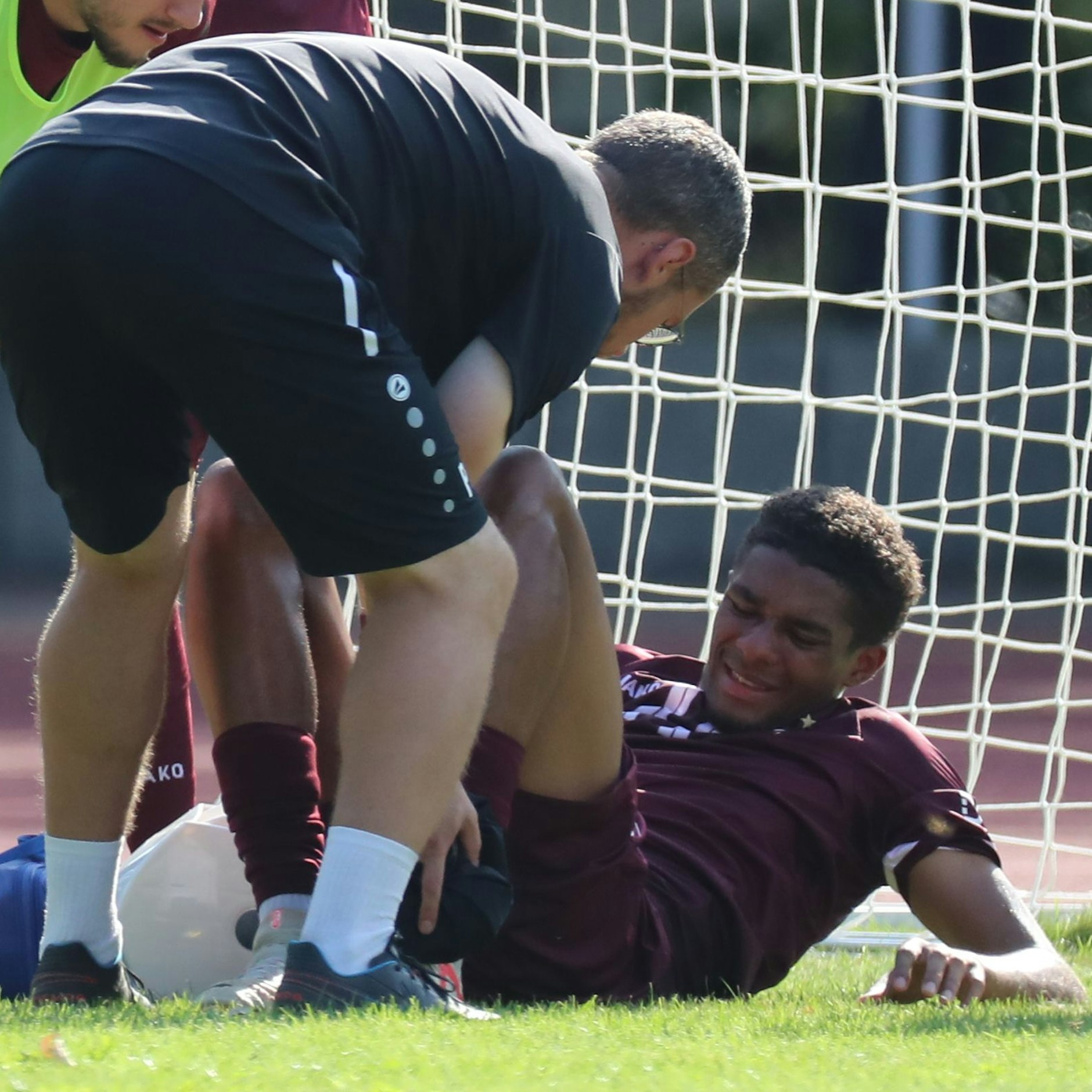 Amiro Amadou im Pokalspiel bei Normannia am Boden, BFC-Physio Pascal Kämper kümmert sich um ihn.