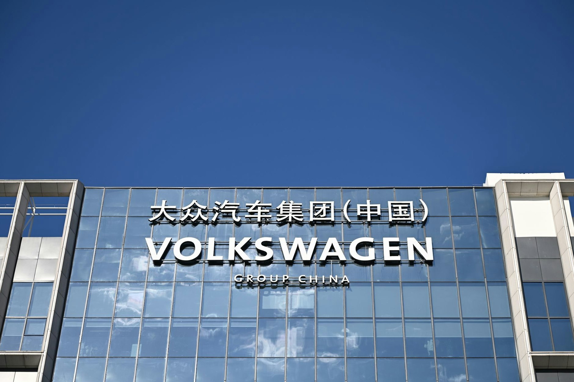 An der Fassade eines Gebäudes ist der Schriftzug der Volkswagen Group in China zu sehen. VW hat in Xinjiang sein umstrittenes Werk verkauft, das die Wolfsburger mit dem chinesischen Staatskonzern Saic betrieben hatten. (zu dpa: «VW in China trennt sich von umstrittenem Werk in Xinjiang»)