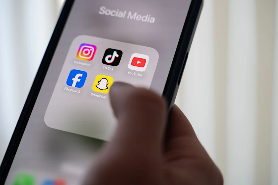 Eine Frau hält ein Smartphone, auf dessen Display verschiedene Social Media Apps angezeigt werden. Unklar ist bislang, welche Plattformen von dem Verbot in Australien für Kinder unter 16 Jahren betroffen sein werden.