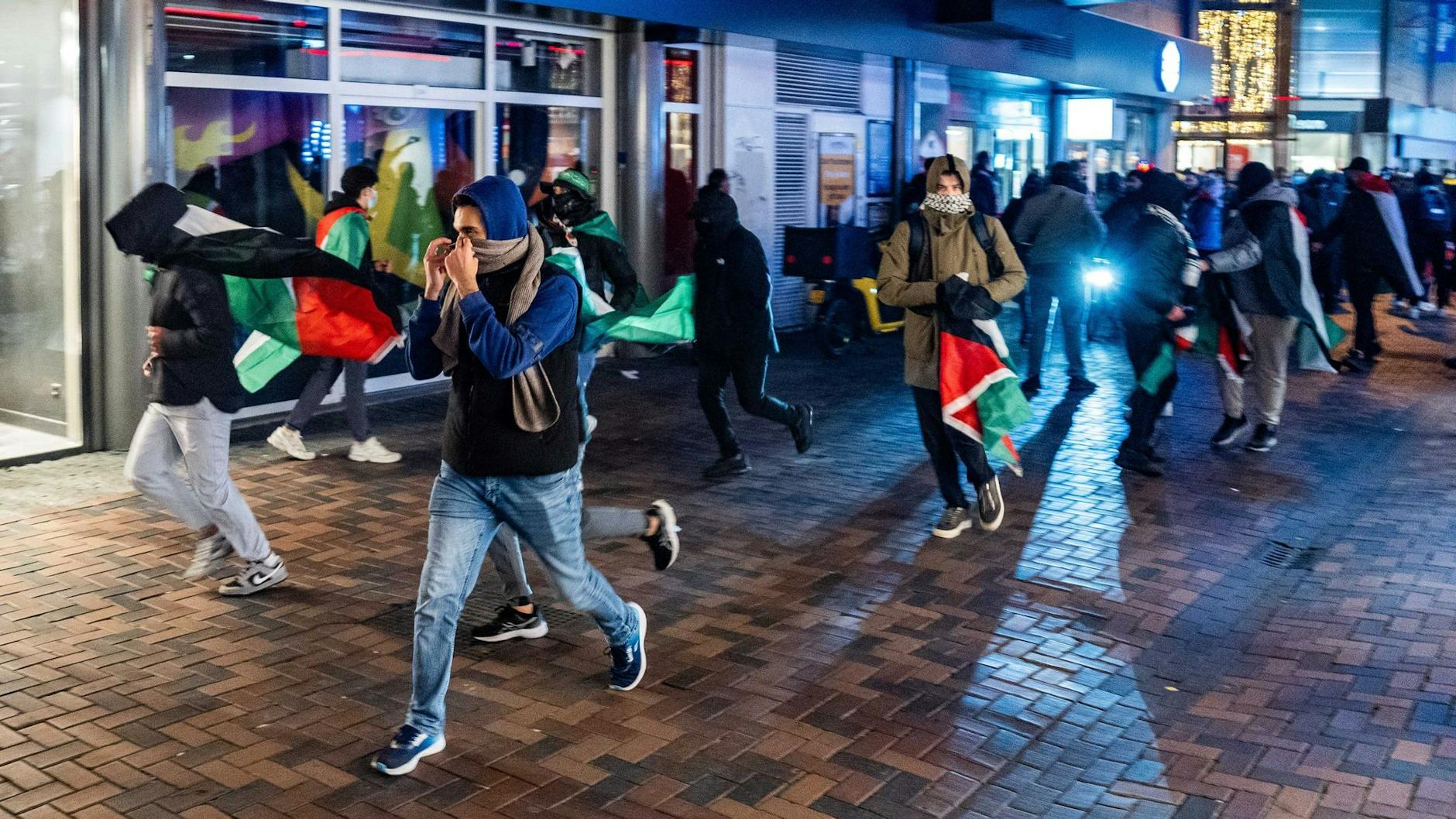 Demonstranten laufen mit palästinensischen Fahnen bei einer propalästinensischen Demonstration während des Spiel Ajax Amsterdam - Maccabi Tel Aviv. Danach kam es zu brutalen Ausschreitungen gegen jüdische Fans.