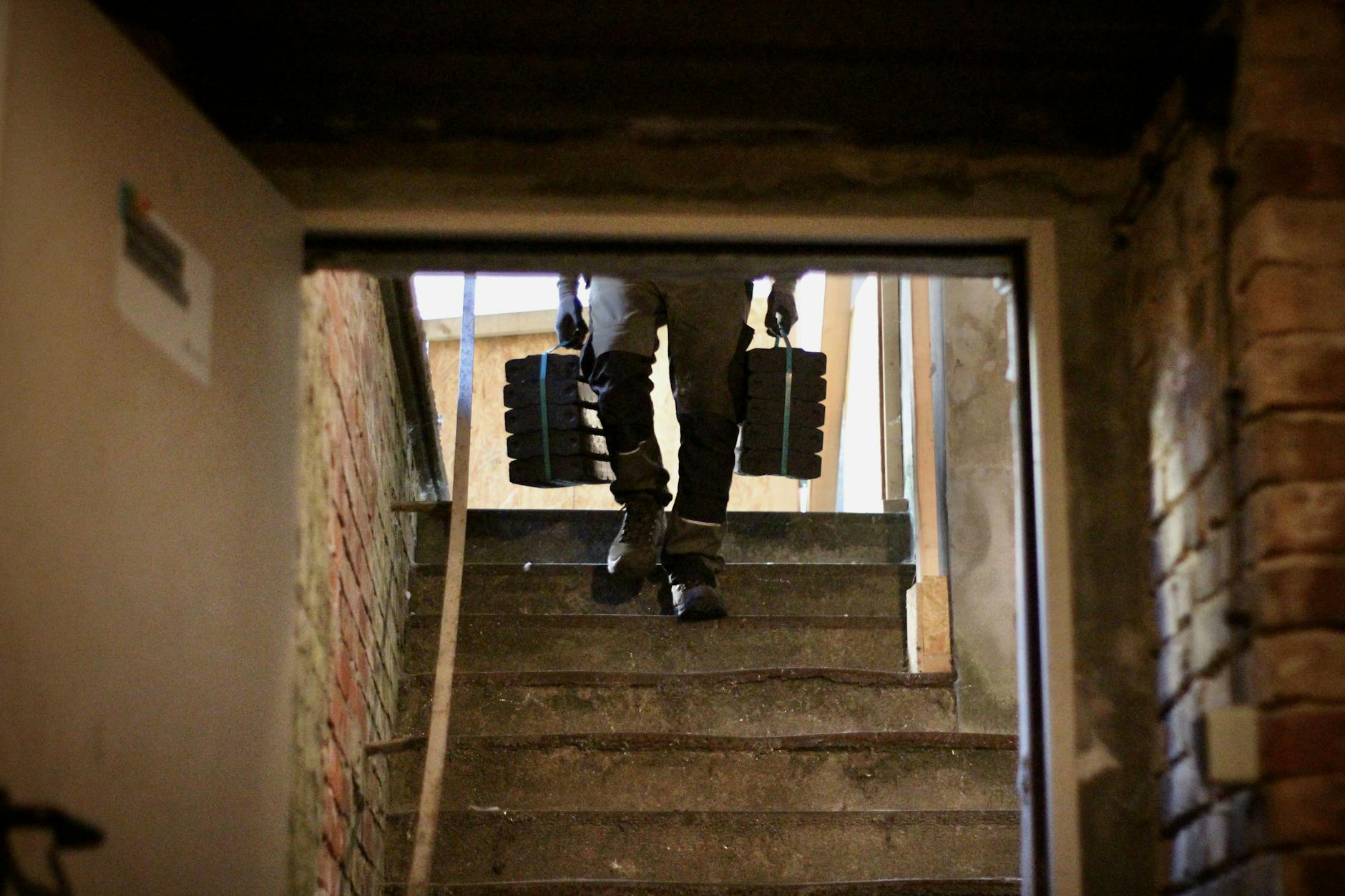 Noch immer heizen viele Berliner Altbauten mit Kohle. Die Kachelöfen sind ein Relikt aus Zeiten, als Kohle der Standard war. Mit reiner Muskelkraft transportieren sie die Kohle in die Keller der Altbauten.