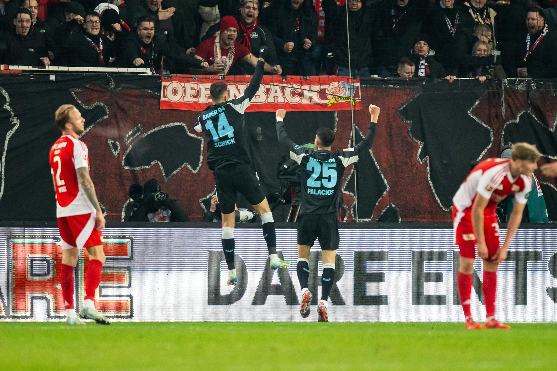 Während Union Berlins Kevin Vogt (l.) enttäuscht das 1:2 gegen Bayer Leverkusen registriert, jubelt Torschütze Patrik Schick (2.v.l.) über seinen Treffer.