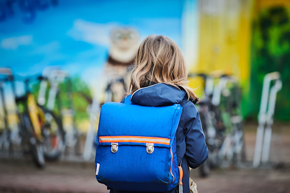 Ein Schüler geht mit Schulranzen über den Schulhof einer Grundschule in Prenzlauer Berg.