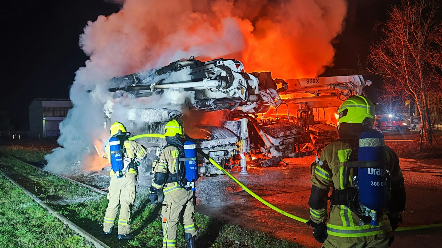 Feuerwehrleute beim Löschen eines brennenden Lkw
