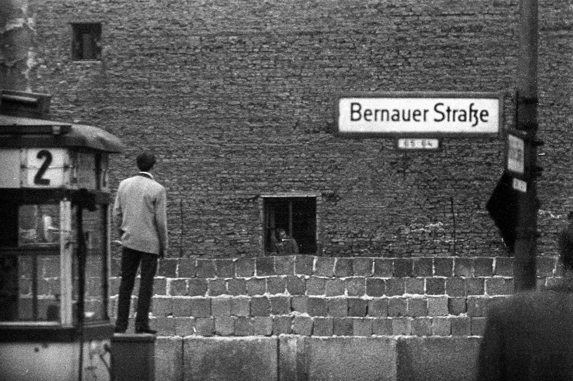 Berliner Mauer an der Bernauer Straße – West-Berliner und Ost-Berliner schauen sich im Jahr 1961 über die Mauer hinweg an.