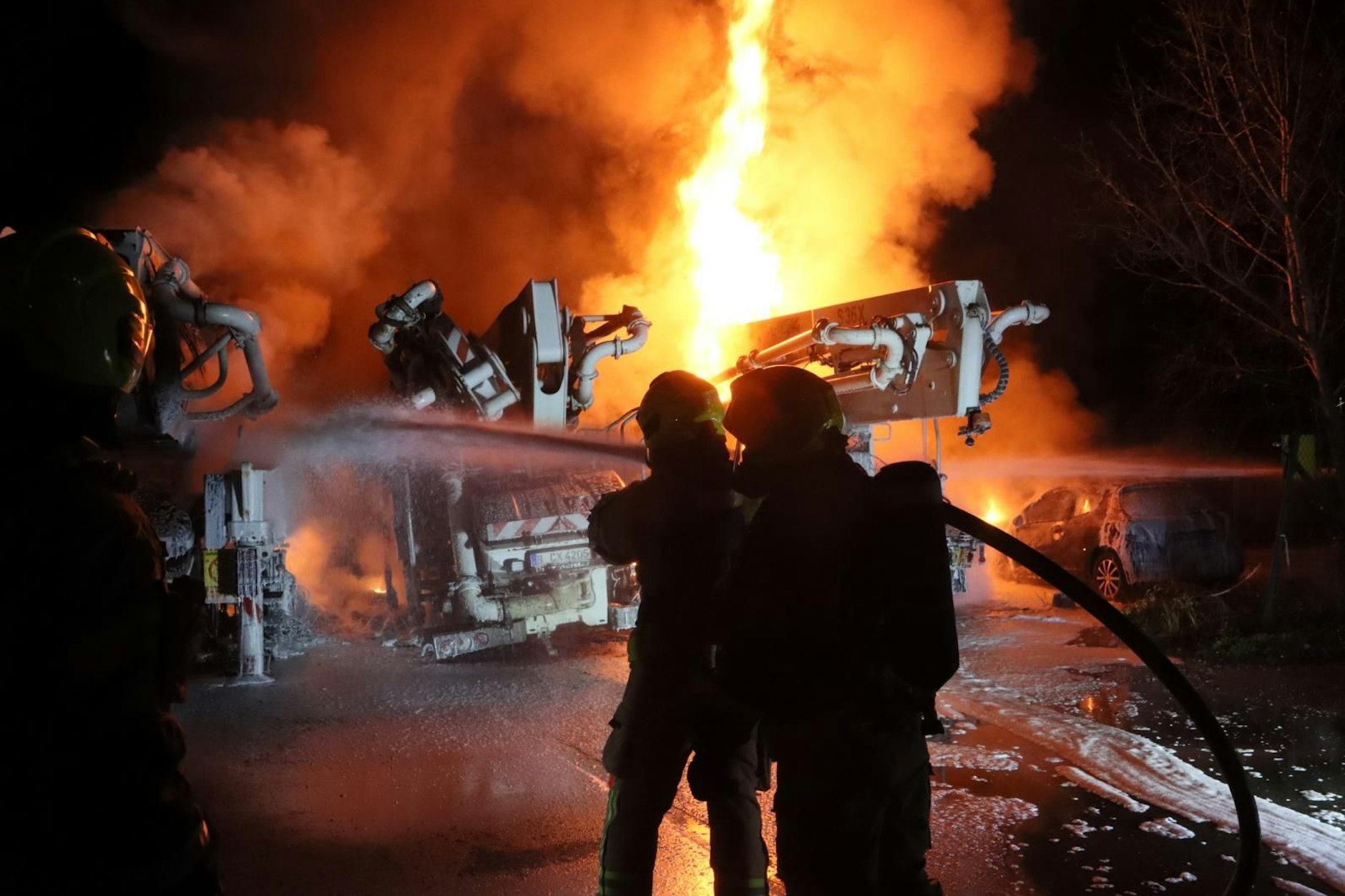 Feuerwehrleute löschen die brennenden Fahrzeuge an der Gehrenseestraße und am Pyramidenring.