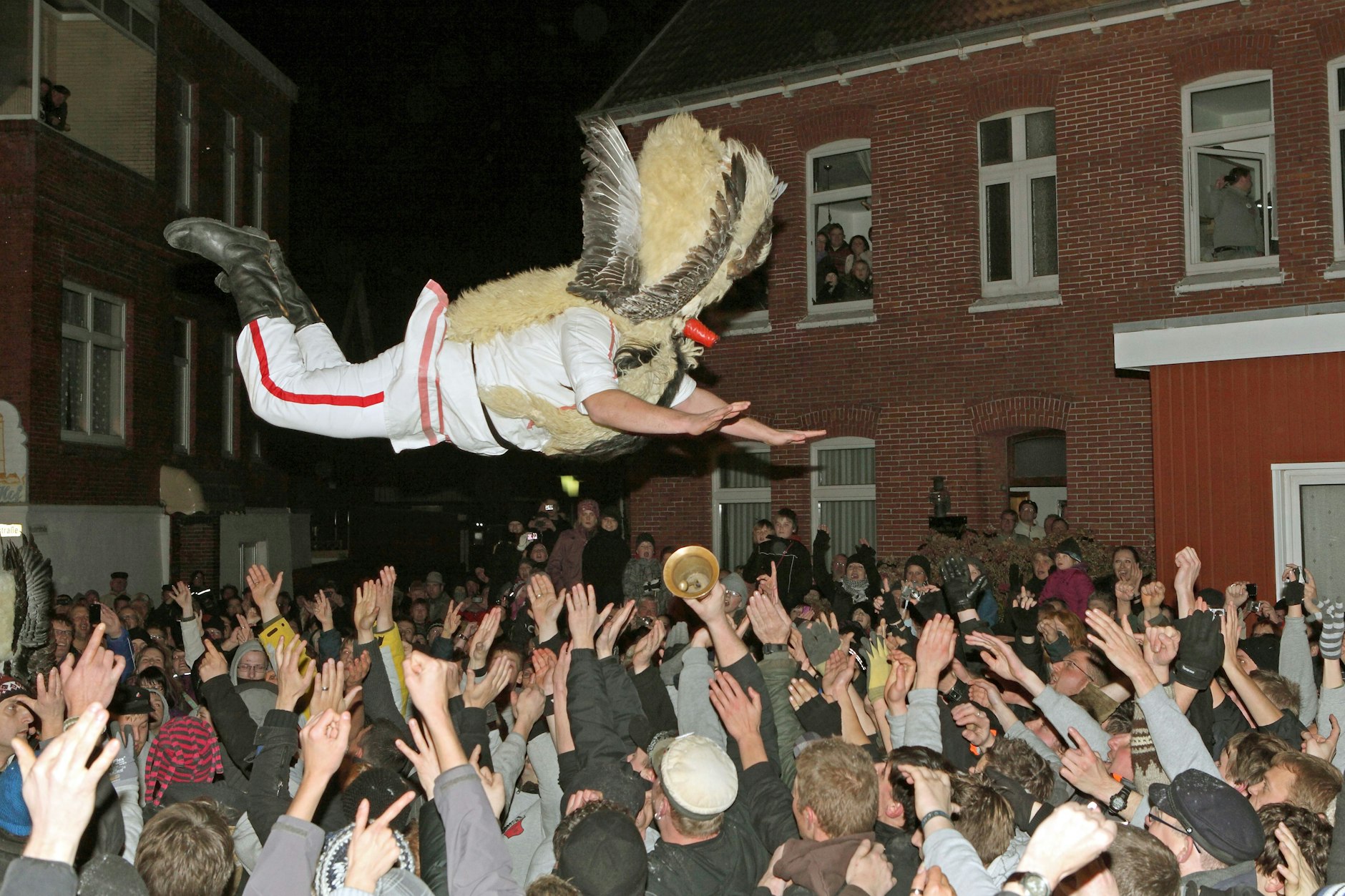 Deutschland, deine Bräuche: Maskierte Männer stürzen sich von einer Litfaßsäule in die Arme der Schaulustigen. Auch so ein Ritual beim traditionellen Klaasohm-Fest.