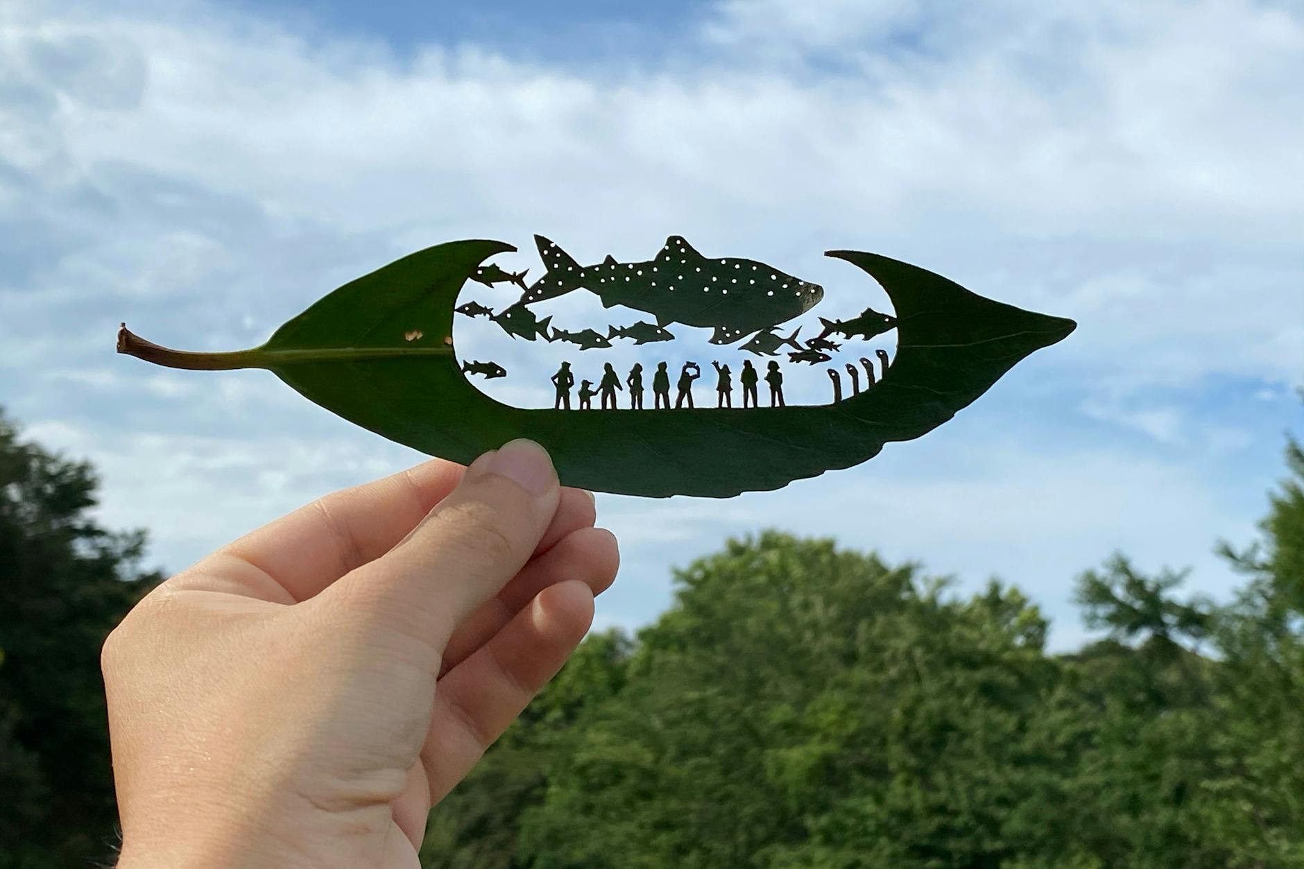 Ein Aquarium mit Fischen und Besuchern auf einem Blatt: eines der vielen filigranen Blattschnitt-Kunstwerke des Japaners Lito.