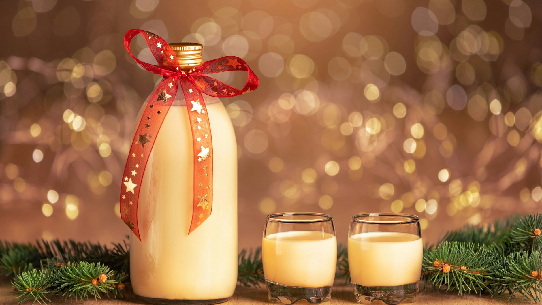 Abgefüllt in einer hübschen Flasche mit Geschenkschleife ist selbst gemachter Eierpunsch auch ein perfektes Mitbringsel zum Weihnachtsessen.