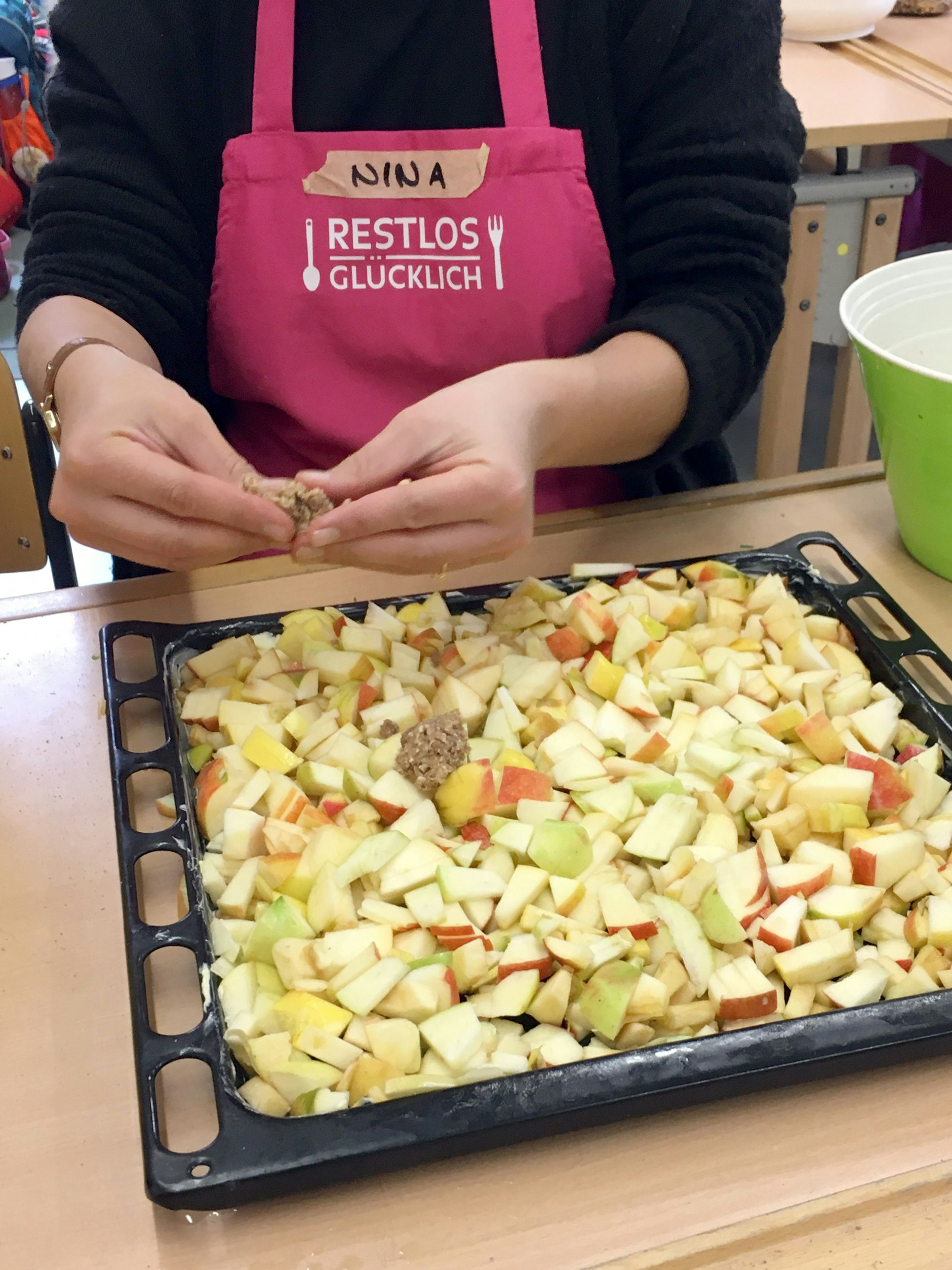 Die Lebensmittel-Expertin Nina Schröder von Restlos Glücklich bereitet während eines Bildungsworkshops für Kinder Apple Crumble zu.